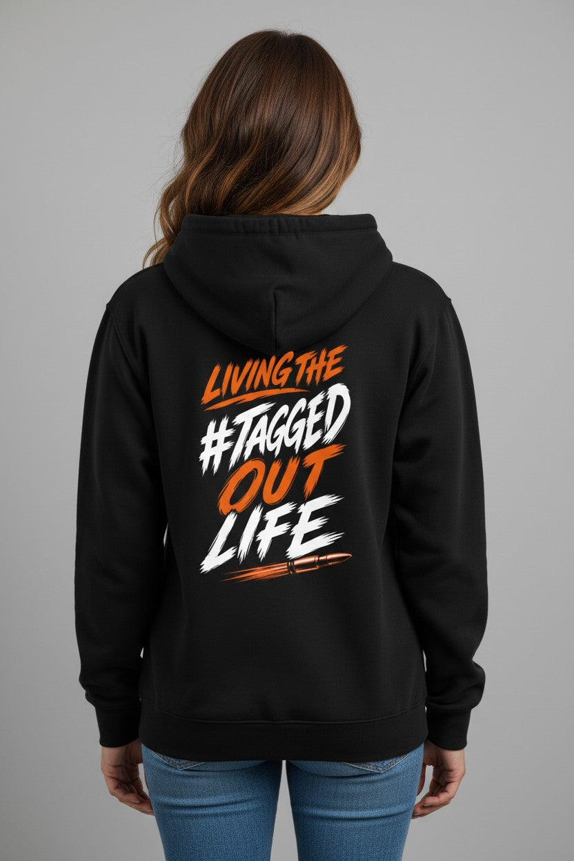 Tagged Out Life black unisex hunting hoodie with rifle graphic and orange text on the back worn by a woman