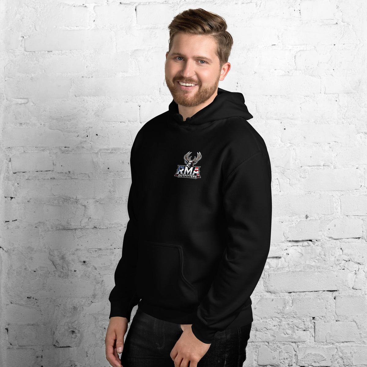 Man wearing a black Tagged Out Life RMA Outfitters NW Missouri hunting hoodie with a small logo on the chest against a brick wall